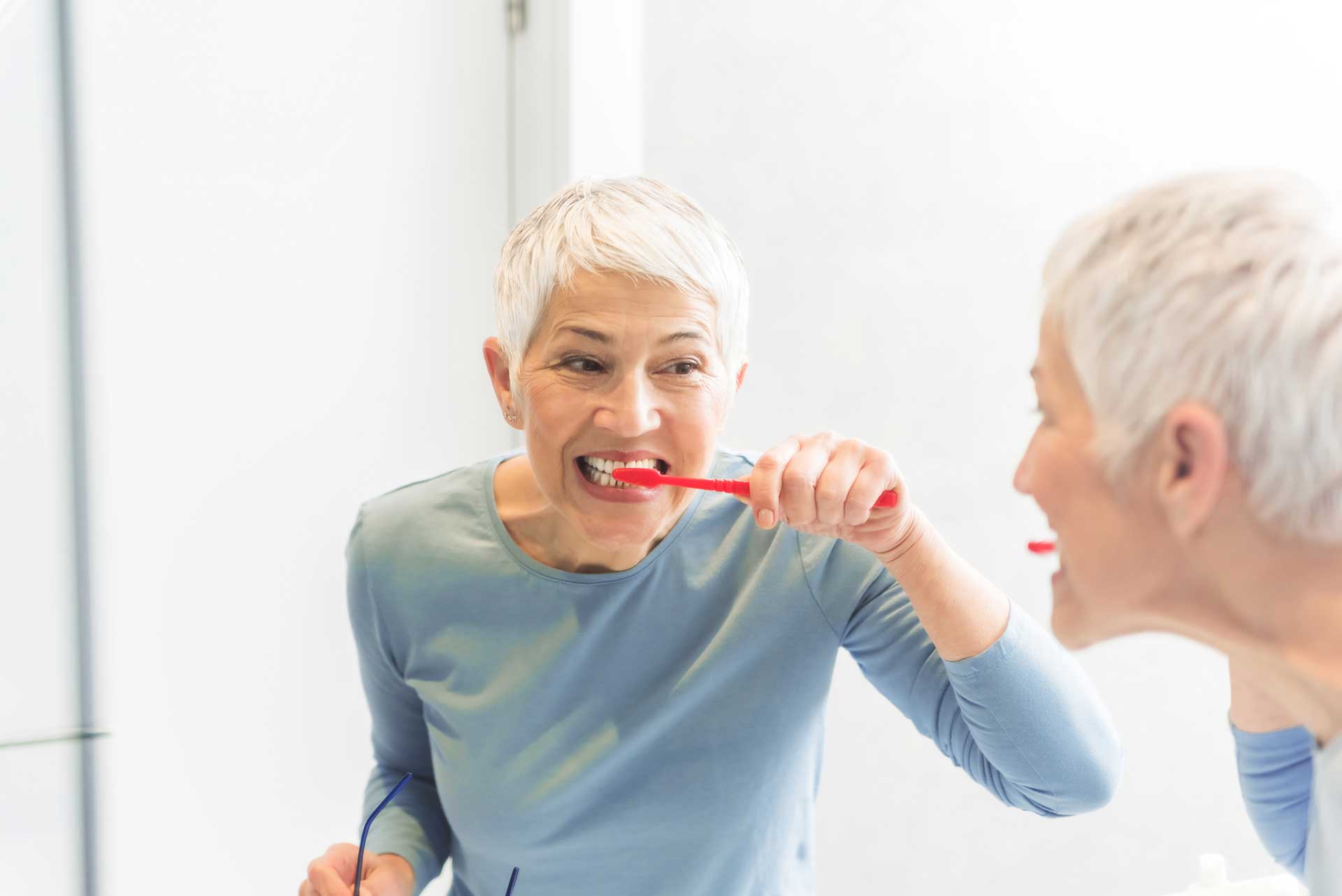 Junge Seniorin beim Zähneputzen